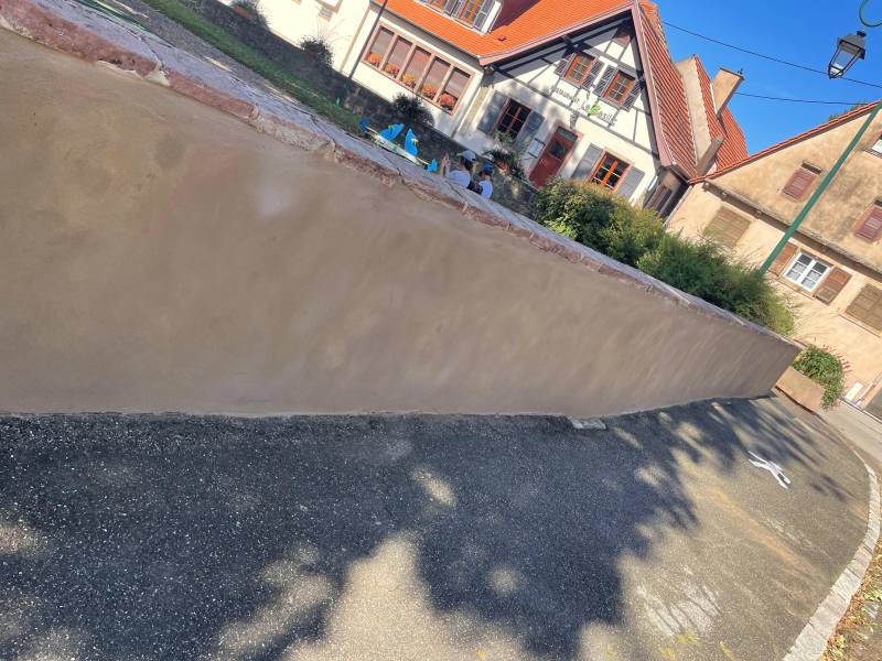 Réfection traditionnelle de mur en crépi mortier chaux-ciment sur parking communal à Avolsheim (67120) dans le Bas-Rhin